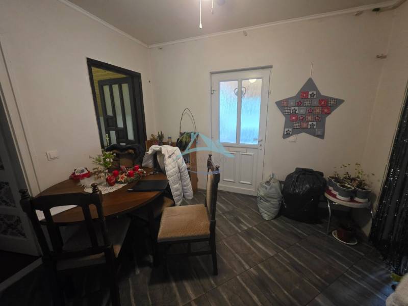 Innenraum eines Einfamilienhauses mit Tisch und Dekorationen, Boden mit Holzdekor.