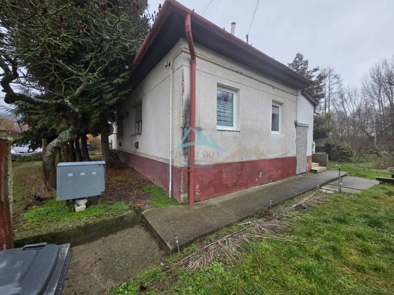 Das Einfamilienhaus in Hont hat eine weiße Fassade, Fenster mit Gittern und Eingangstreppen.