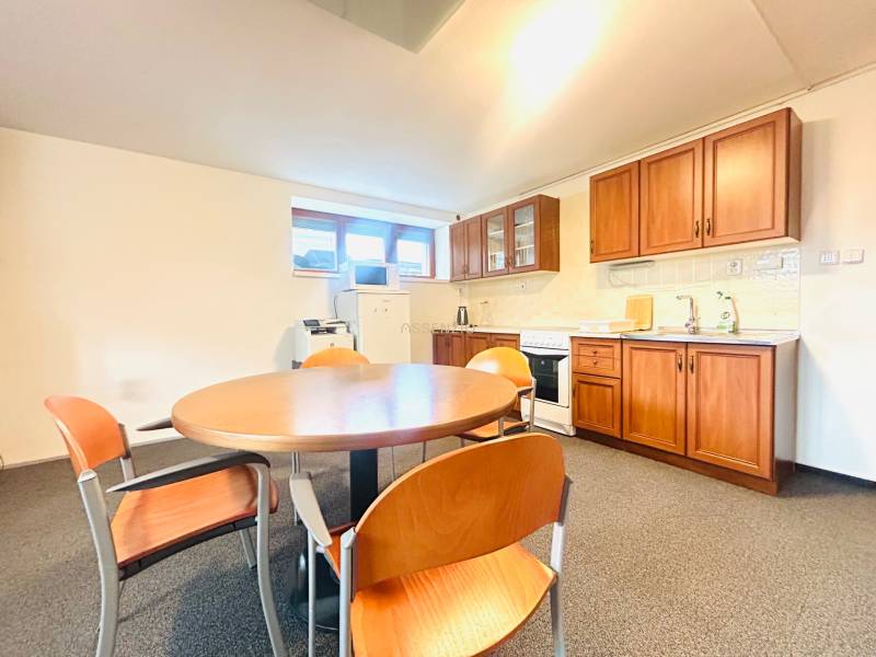 Eine Küche in einem Einfamilienhaus mit Esstisch, Stühlen und einer Küchenzeile mit Holzdekor.