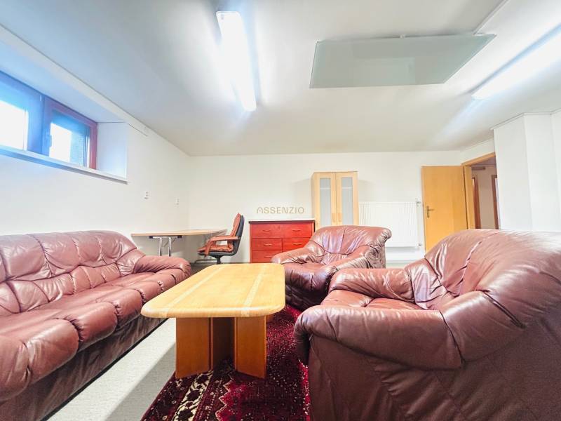 Ledergarnitur mit Couchtisch, Teppich und Arbeitsecke im Einfamilienhaus.