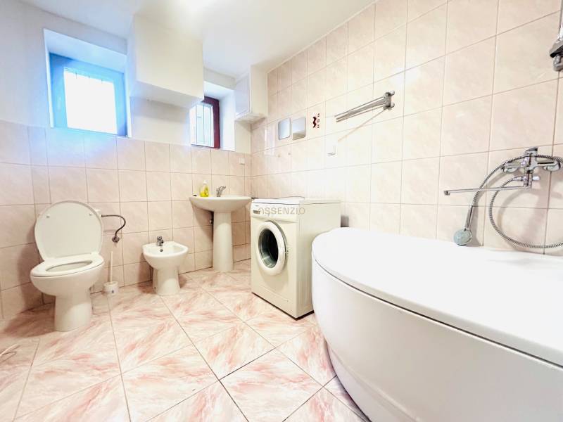 Badezimmer in einem Einfamilienhaus mit Badewanne, Toilette, Bidet und Waschmaschine.