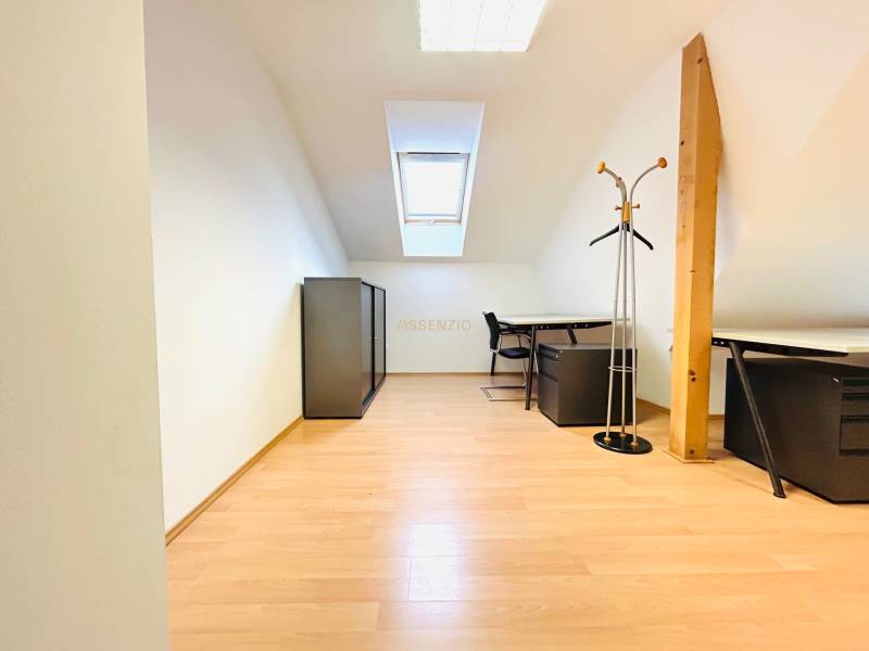 Büros mit Holzboden, Oberlicht, Möbel und Kleiderständer.