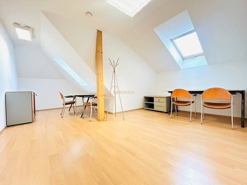 Büros mit Holzboden, Dachfenster, Tische und Stühle.