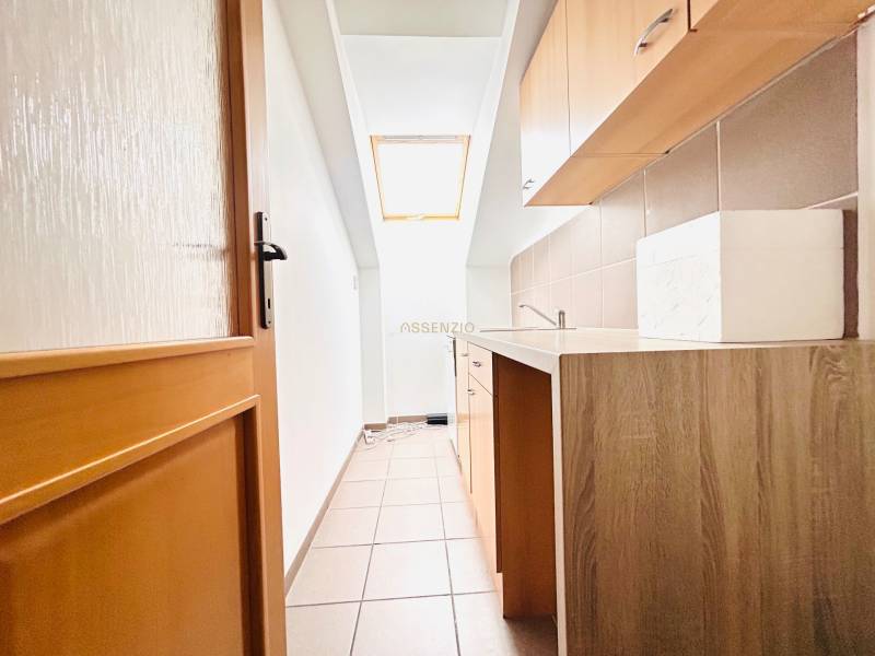 Schmale Küchenzeile im Büro mit Fenster und Boden in Holzoptik.