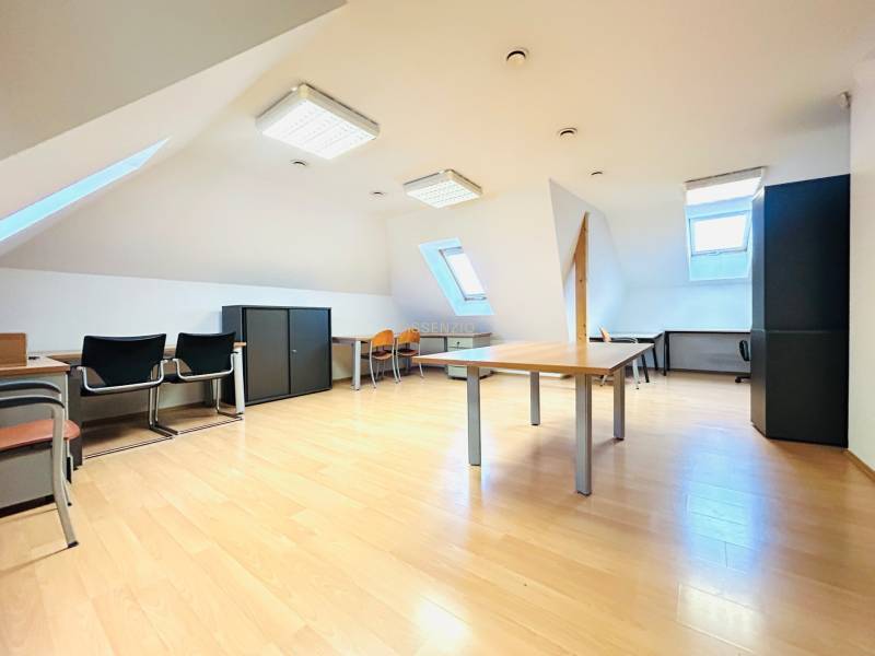 Dachgeschossbüros mit Holzboden, Dachfenstern und Büroausstattung.