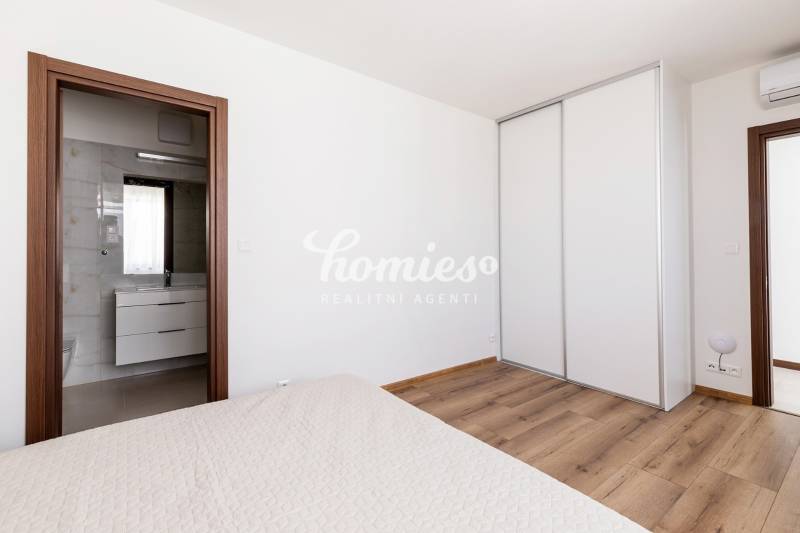 Schlafzimmer in einer 3-Zimmer-Wohnung mit Holzboden und Einbauschrank.