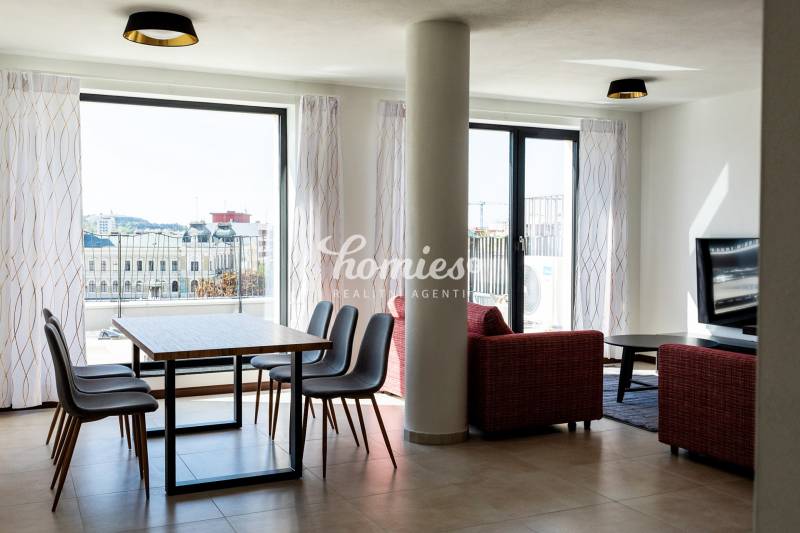 Wohnzimmer in einer 3-Zimmer-Wohnung mit Esstisch und Blick auf die Stadt.
