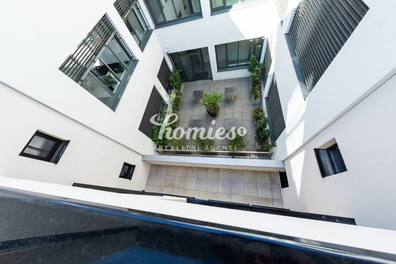 Innenhof des Wohnkomplexes in Nitra mit Terrassenpflaster und Grünflächen.