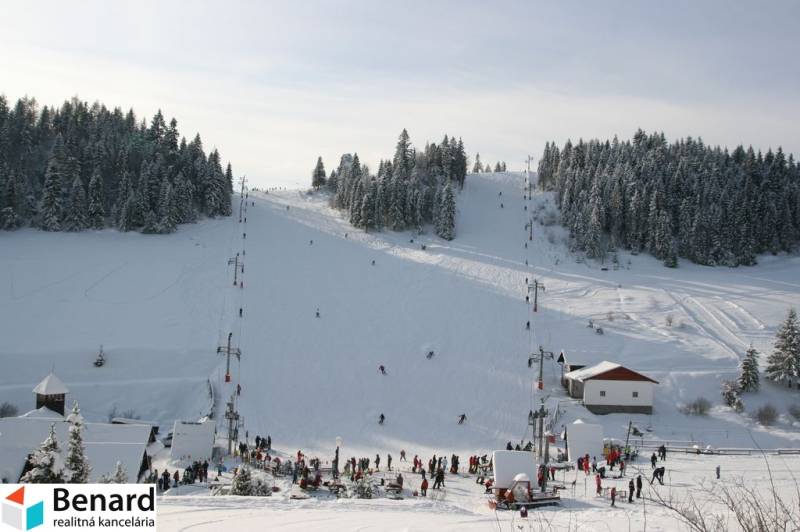 Skigebiet auf den Erholungsgrundstücken in Litmanová mit Skifahrern und verschneiten Wäldern.