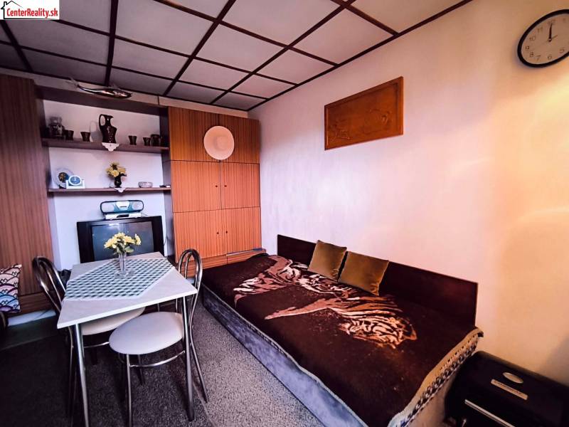 Das Innere der Hütte mit einem Sofa, einem Esstisch und einem Einbauschrank wird von einer natürlichen Farbpalette dominiert.