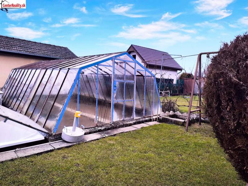 Garten in Partizánske mit einem überdachten Aufstellpool, Schaukel, grüner Rasen.