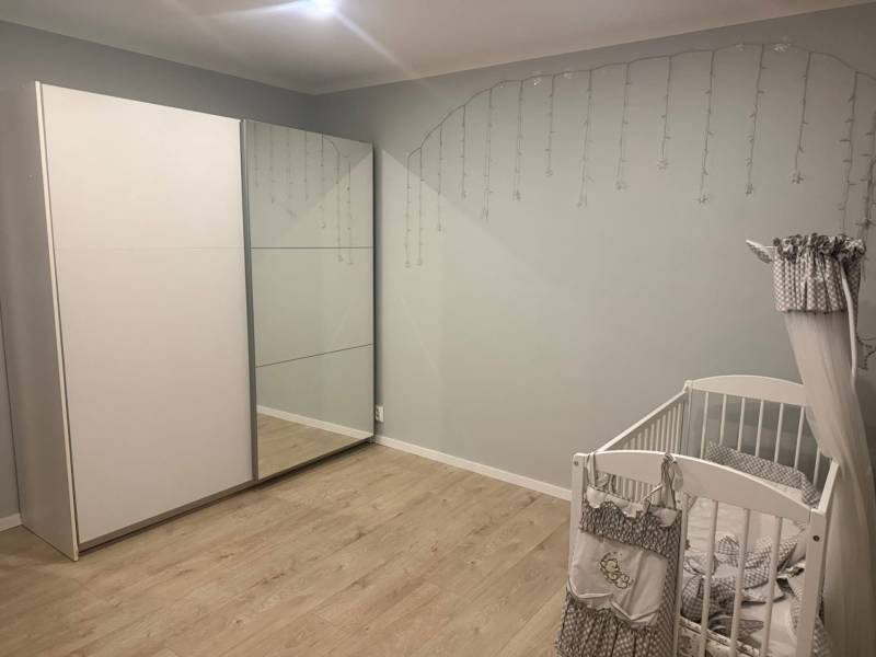 Kinderzimmer in einer 3-Zimmer-Wohnung mit Holzboden, Kinderbett und Kleiderschrank.