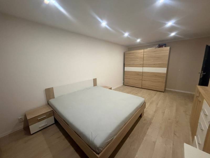Schlafzimmer in einer 3-Zimmer-Wohnung mit Möbeln in Holzdekor, Boden mit Holzdekor.