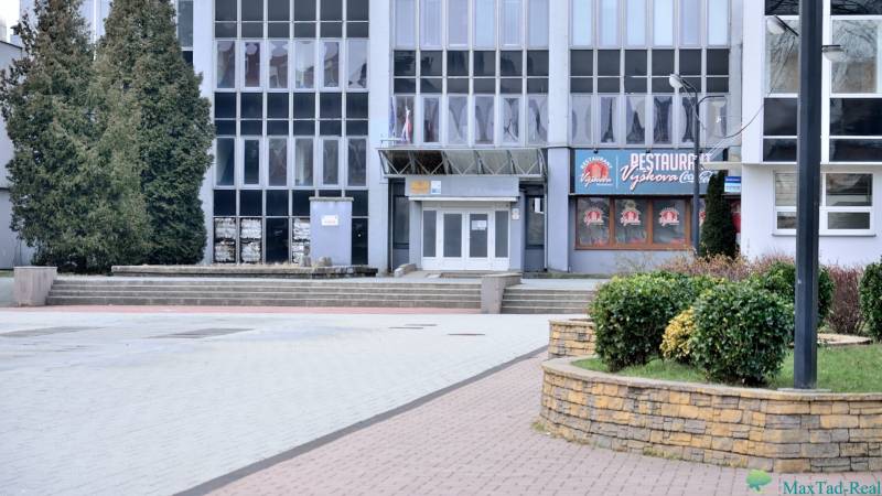 Ein Bürogebäude am Freiheitsplatz in Michalovce, umgeben von Grünflächen und Gehwegen.