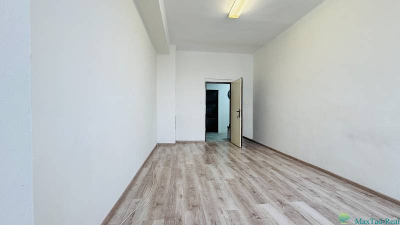 Büros mit weißen Wänden und einem Boden in Holzoptik, offene Türen.