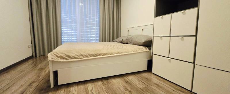 Schlafzimmer im Einfamilienhaus mit Bett und Schrank, Boden mit Holzdekor.