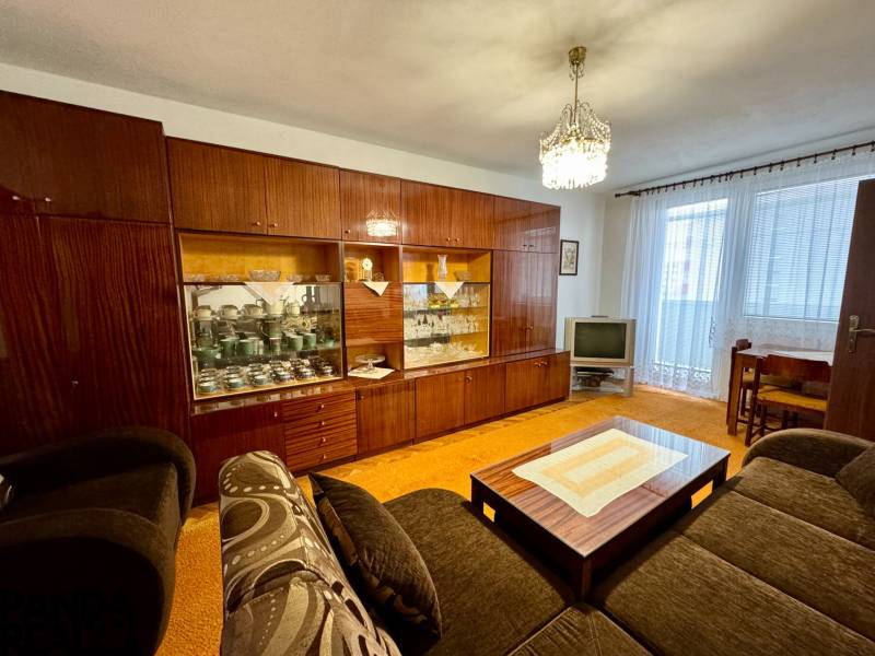 Wohnzimmer mit rustikaler Wohnwand und Fernseher in einer 3-Zimmer-Wohnung.