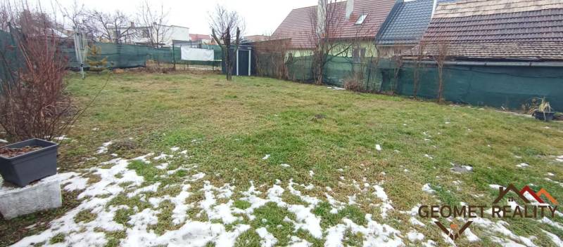 Der Garten beim Einfamilienhaus in der Friedhofstraße in Divín, bedeckt mit Gras und Schnee.