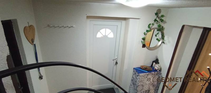 Eingang zum Einfamilienhaus mit weißen Türen, Spiegel und dekorativen Elementen.