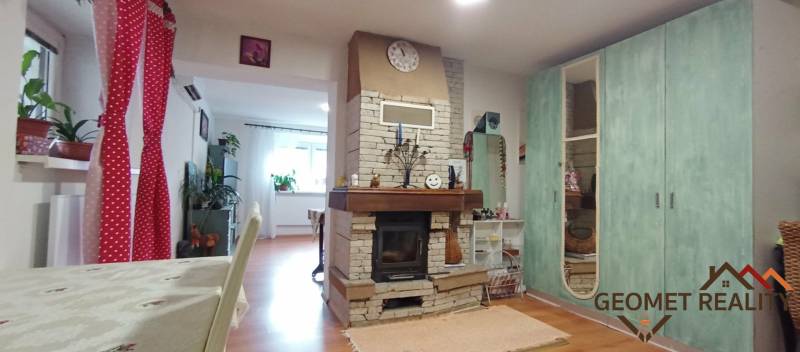 Innenraum eines Einfamilienhauses mit Kamin und Bodenbelag in Holzoptik, ergänzt durch eine bunte Dekoration.