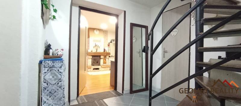 Innenraum eines Einfamilienhauses mit Treppe, Holzboden und Kamin.