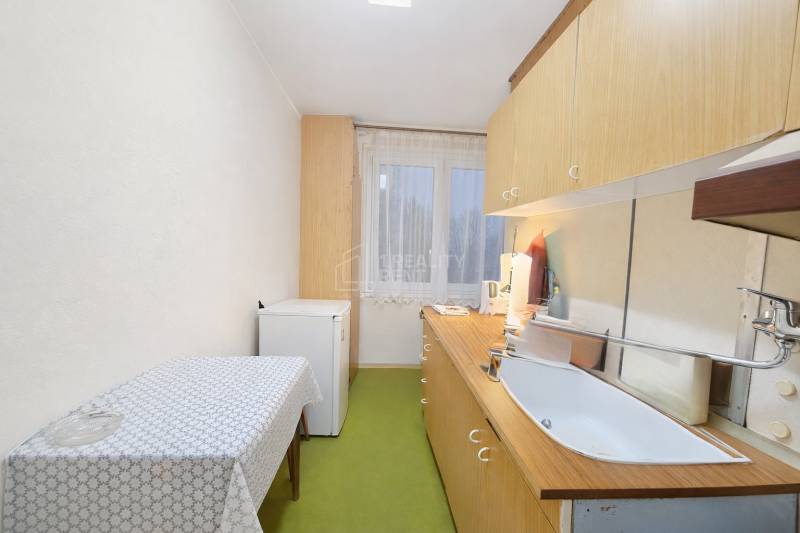 Küche in einer 3-Zimmer-Wohnung mit einfacher Einrichtung, Boden mit Holzdekor.