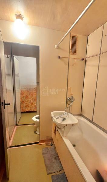 Badezimmer in einer 3-Zimmer-Wohnung mit Badewanne und Waschbecken.