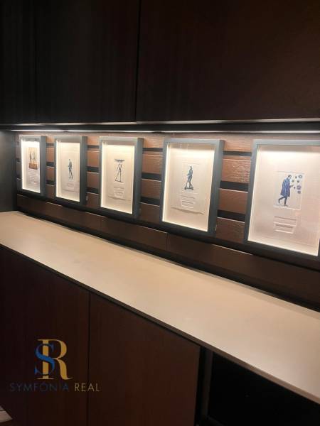 Gerahmte Bilder auf einem Holzregal in einer Zweizimmerwohnung.