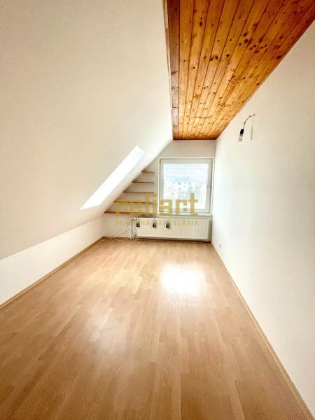 Dachbodenraum in einem Einfamilienhaus mit Holzboden und Dachfenster.