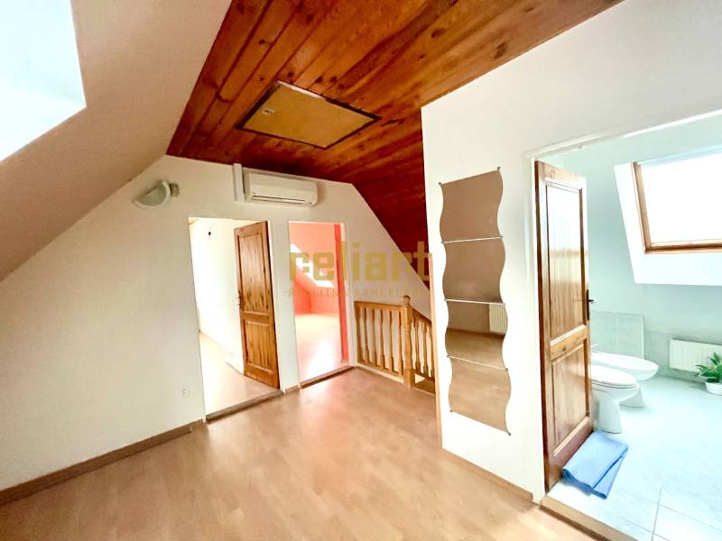 Innenraum eines Einfamilienhauses mit Holzboden und Dachfenster.