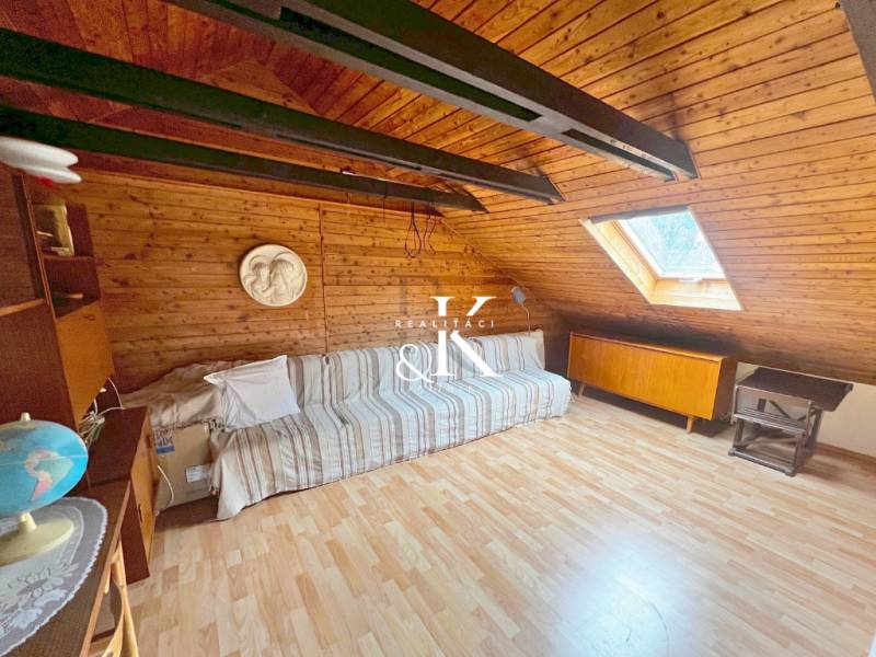 Dachzimmer in einer Hütte mit Holzboden und Dachfenster.