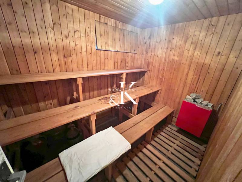 Eine Holzsauna mit Bänken und einem Ofen in einer Hütte.