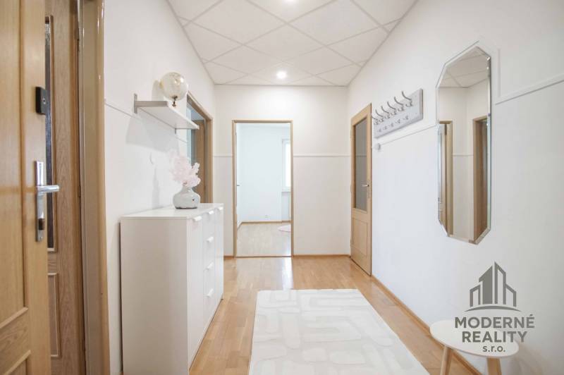 Flur in einer 4-Zimmer-Wohnung mit Holzboden, einfach eingerichtet.