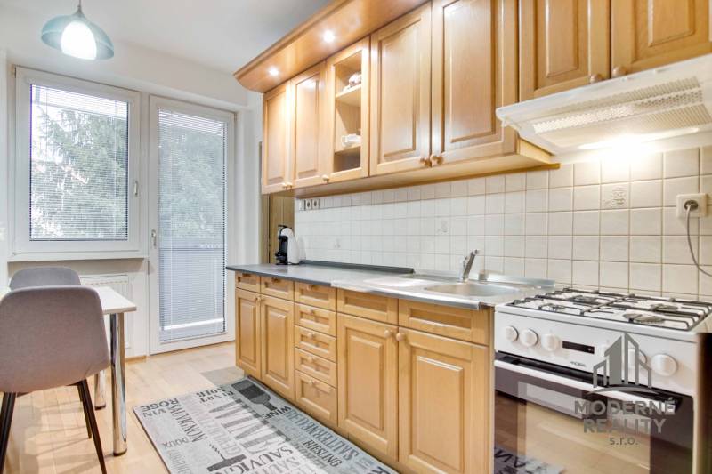 Küche in einer 4-Zimmer-Wohnung mit Holzboden und Essecke.