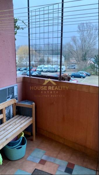 Balkon mit einer Holzbank, Blick auf geparkte Autos, Straße Jána Poničana, Bratislava - Devínska Nová Ves.