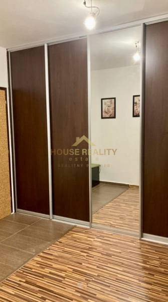 Schrank mit Schiebetüren und Spiegel in einer 3-Zimmer-Wohnung mit Holzboden.