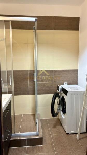 Badezimmer mit Dusche und Waschmaschine in einer 3-Zimmer-Wohnung.