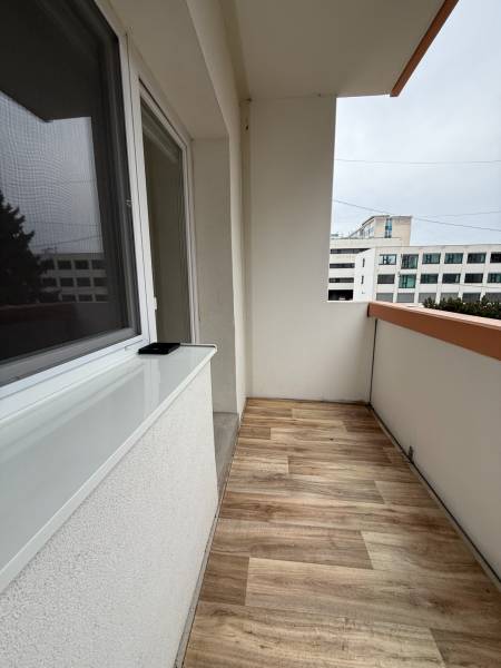 Balkon in einer Einzimmerwohnung mit Holzboden-Dekor.