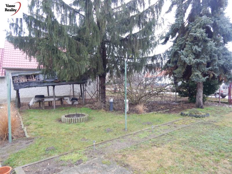 Ein Garten bei einem Einfamilienhaus in Kravany nad Dunajom mit einem Pavillon und Nadelbäumen.