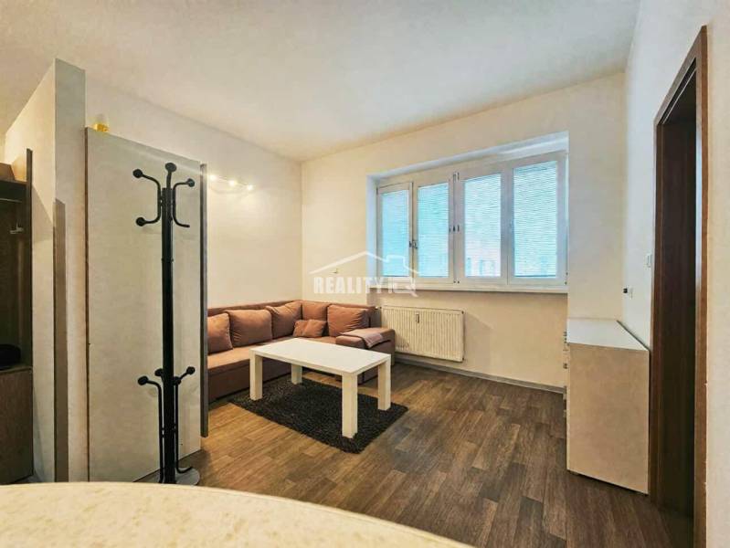 Garçonniere mit Sofa, Tisch und Holzboden.