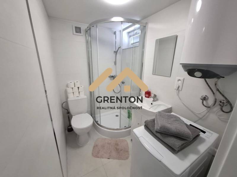 Badezimmer mit Badewanne, Waschmaschine, Boiler und Waschbecken in einer Hütte. Minimalistisches Design.