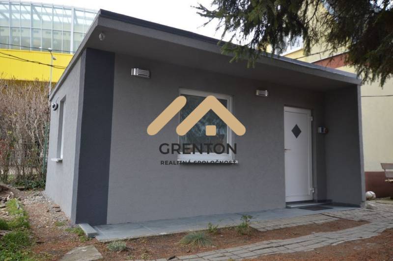 Ein Ferienhaus mit grauer Fassade in Bratislava - Ružinov in der Studená Straße, umgeben von Grün.