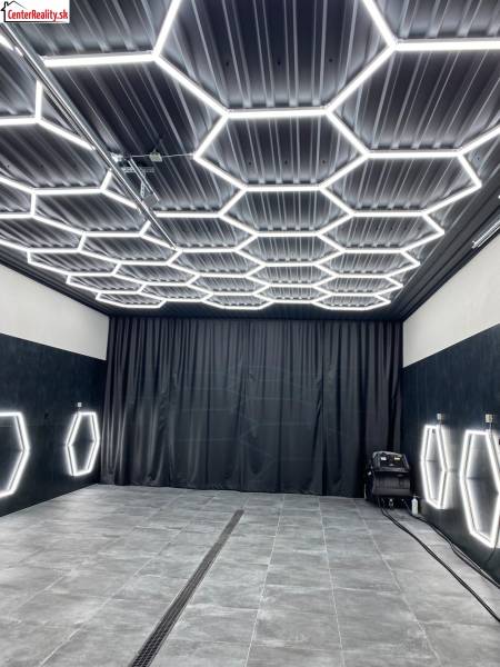 Geschäftsräume mit dunklem Dekor und sechseckiger LED-Beleuchtung an Decke und Wänden.