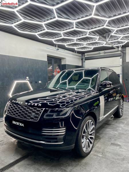 Geschäftsräume mit beleuchtetem Dach und Luxusfahrzeug.