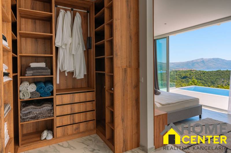 Ein Kleiderschrank in einer Villa mit Meerblick, Holzboden, Pool.