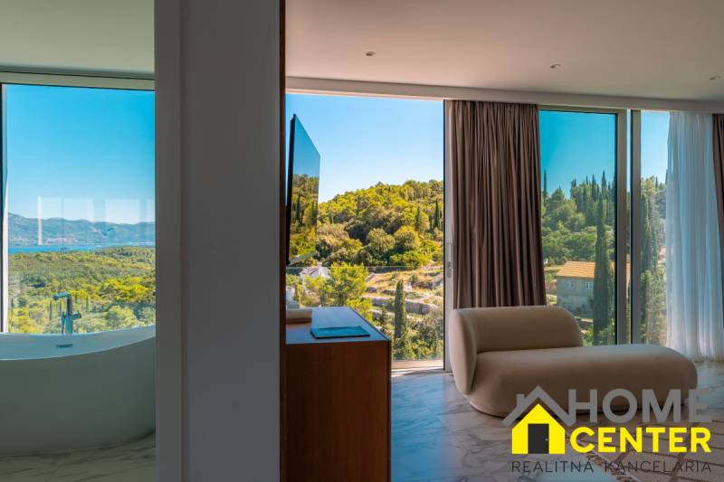Interieur der Villa mit Blick auf die Natur, Badewanne am Fenster, bequemer Sessel.
