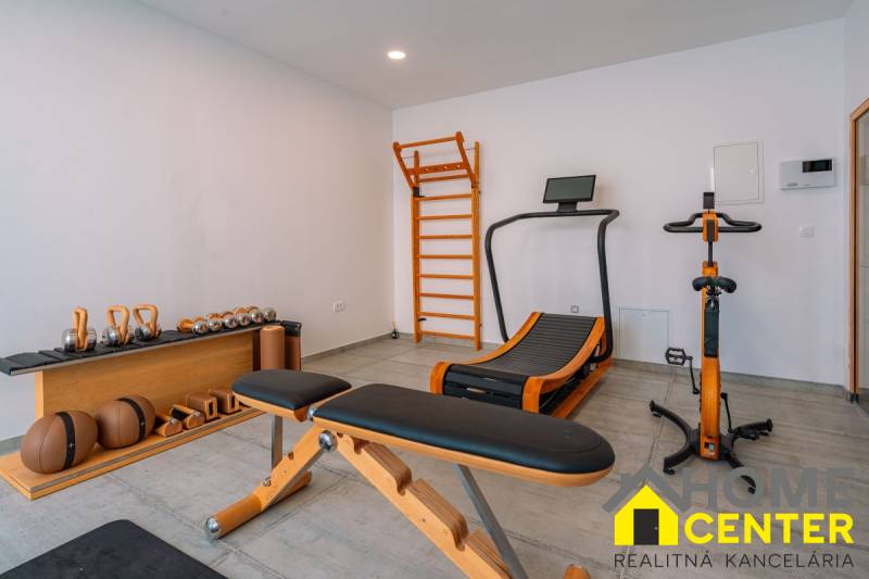 Fitnessstudio in der Villa mit Ausstattung: Bank, Laufband, Hanteln, Sprossenwand.