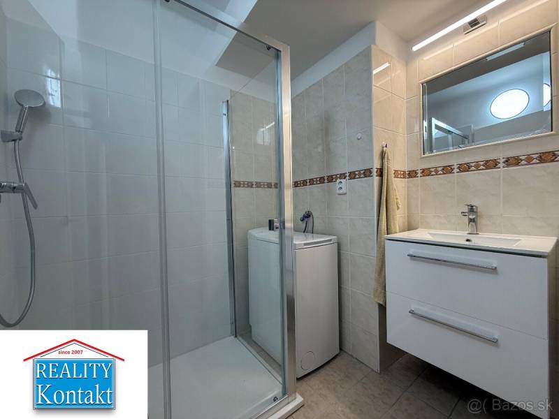 Badezimmer in einer 2-Zimmer-Wohnung mit Waschbecken, Dusche und Waschmaschine.