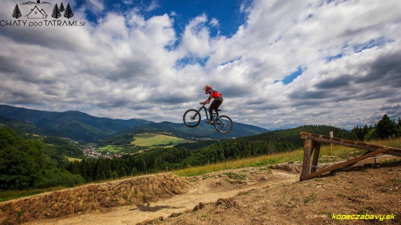 Ein Radfahrer springt mit einem Mountainbike über die Landschaft im Erholungsgebiet bei Mýto pod Ďumbierom.