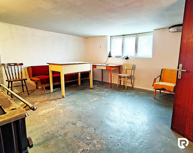 Keller in einem Einfamilienhaus mit Möbeln und Fenster, Betonboden.